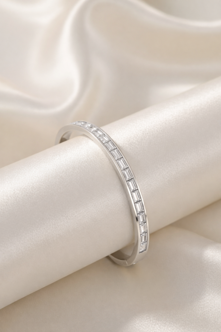 Silver slim bangle bracelet with baguette-cut cubic zirconia stones on satin background