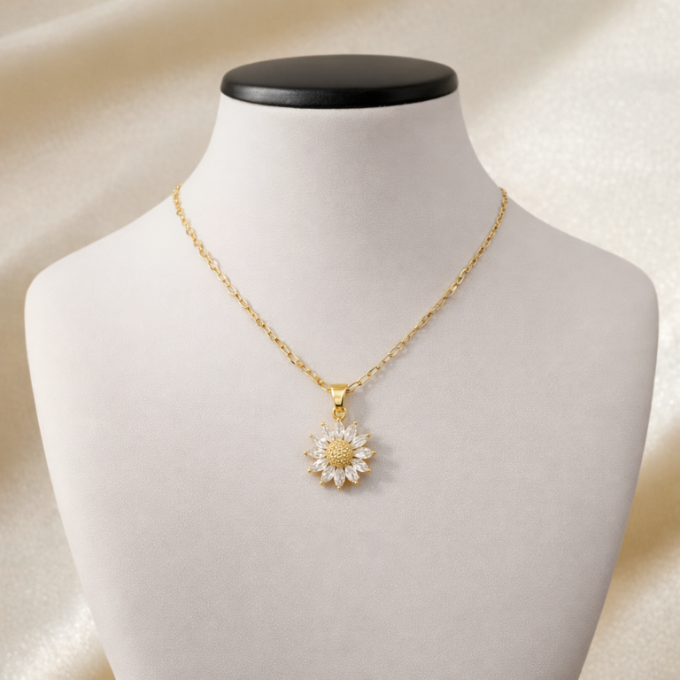 Gold necklace with crystal flower pendant and textured center displayed on jewelry bust