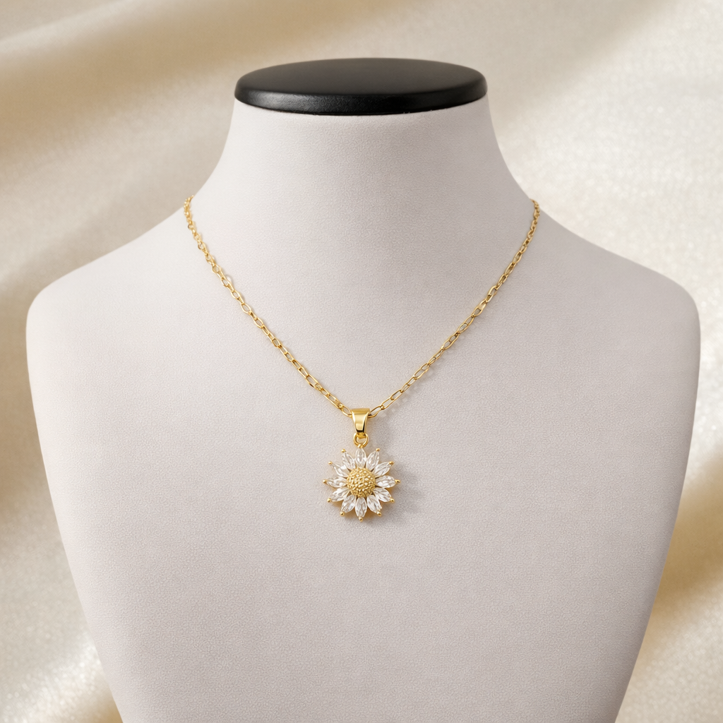 Gold necklace with crystal flower pendant and textured center displayed on jewelry bust