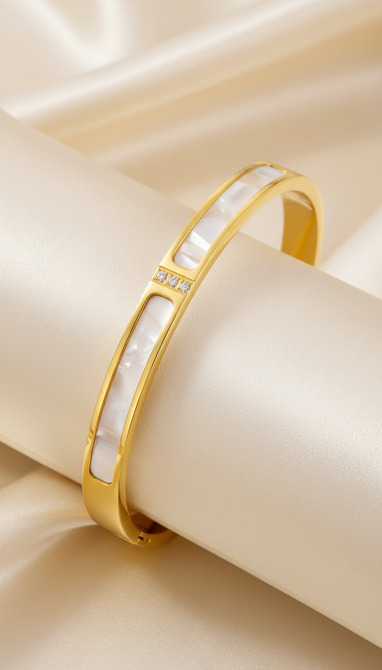 Description Discover the Stainless Steel 18K Gold Plated Crystal Frame Bangle — a beautifully crafted piece of non-tarnish, waterproof jewelry designed for everyday elegance. Featuring smooth white enamel inlay panels framed in polished gold and accented with three precision-set cubic zirconia stones, this bangle blends modern minimalism with subtle sparkle. Key Features Material: Premium stainless steel with 18K gold PVD plating Finish: Non-tarnish and waterproof for lasting shine Design: White enamel inlay with triple cubic zirconia accent Size: (add diameter in cm/inches) Hypoallergenic: Gentle on skin suitable for everyday use Style: Modern chic — perfect for statement styling or stacking Why You’ll Love It Crafted with high-quality gold plating and durable stainless steel, this bangle delivers luxury design with everyday resilience. Its waterproof and non-tarnish finish ensures long-lasting brilliance — ideal for women who appreciate clean lines with a touch of sparkle. Perfect For Everyday wear Office and formal styling Minimal statement looks Gift for her (Anniversary, Birthday, Valentine’s Day, Mother’s Day) Care Instructions To keep your bangle radiant: Avoid contact with perfumes, lotions, and harsh chemicals Remove before swimming or bathing Store in a dry place after use